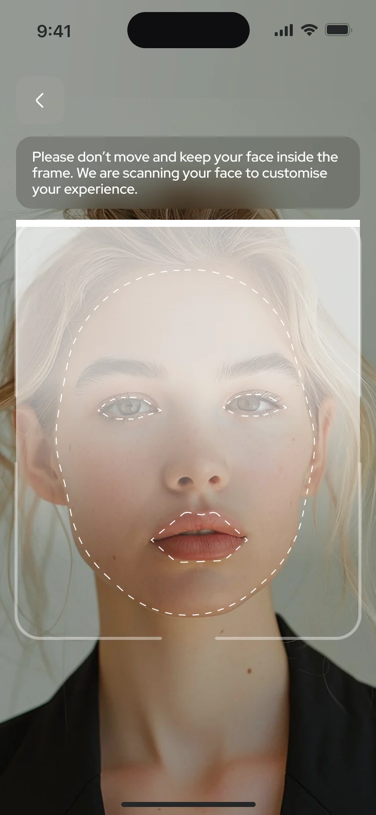 The makeup guide begins on the live camera: a face inside a frame with a line asking the person to keep still while it is scanned