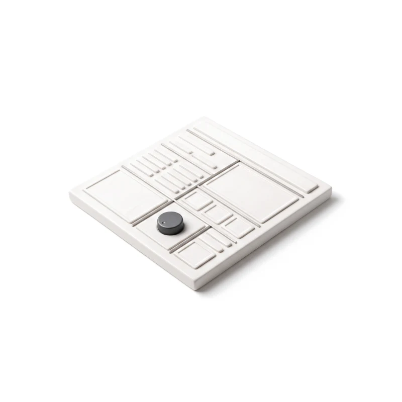 A thin ceramic web-page slab carved into flat plain sections, with one small raised graphite dial on a single section.