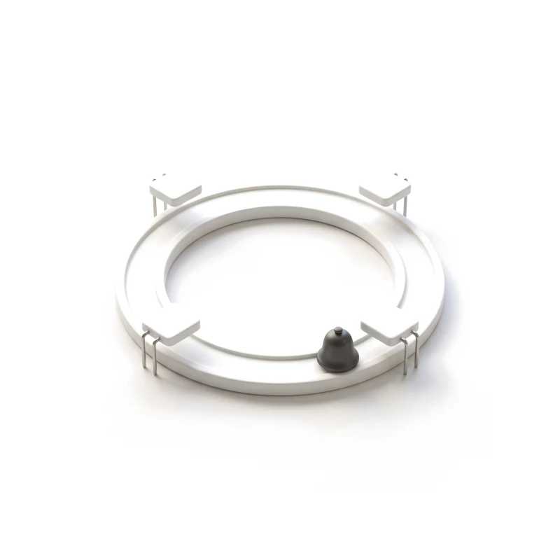 A white ceramic ring track with four stations on steel pins and a small graphite bell resting on it.