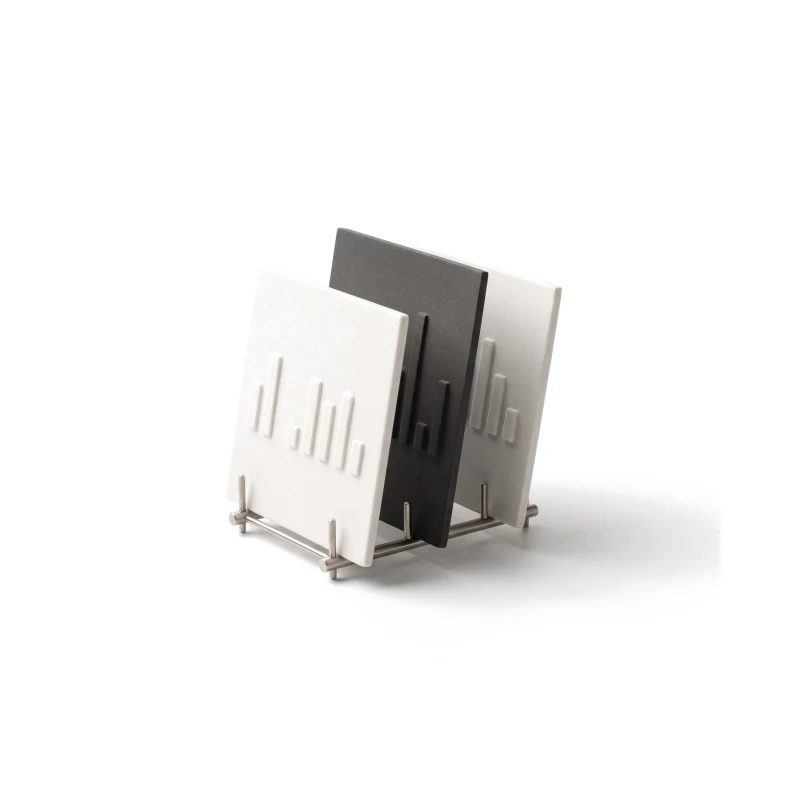 Three ceramic plan cards carved with bars, standing in a steel rack, the middle one in graphite.