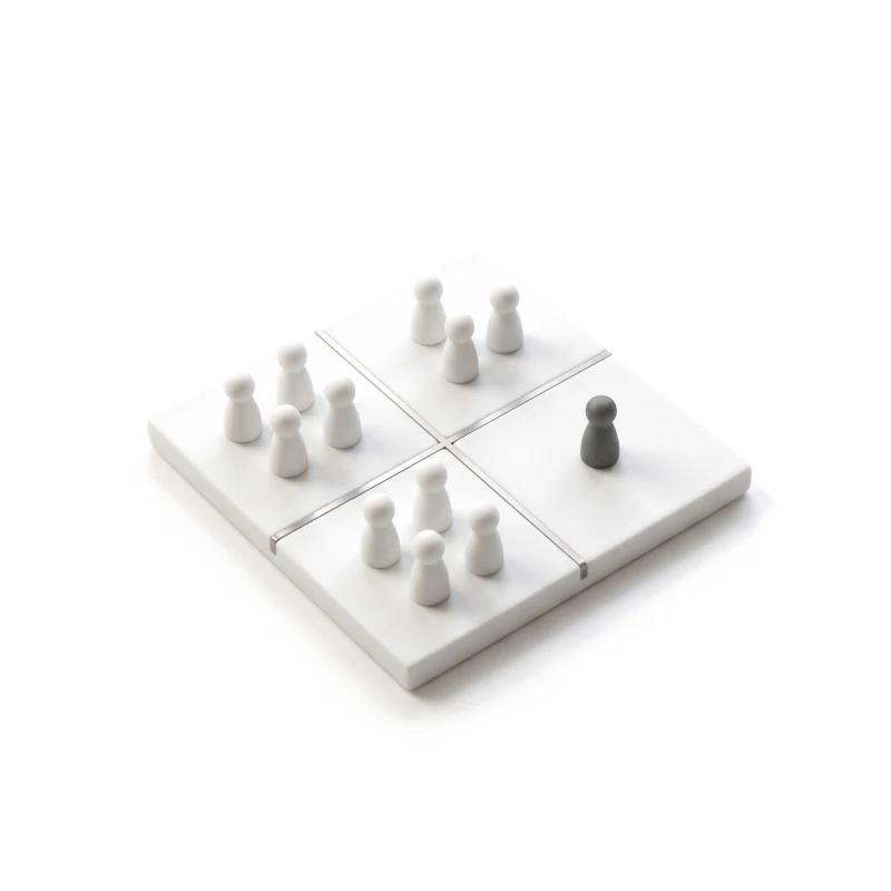 A white ceramic board split into four by thin steel lines, white pawns grouped in three parts and one graphite pawn alone in the fourth.