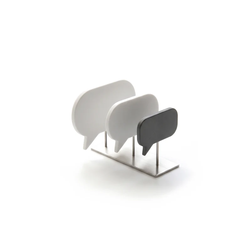 Three ceramic speech-bubble tiles of different sizes on a thin steel stand, the smallest one graphite.