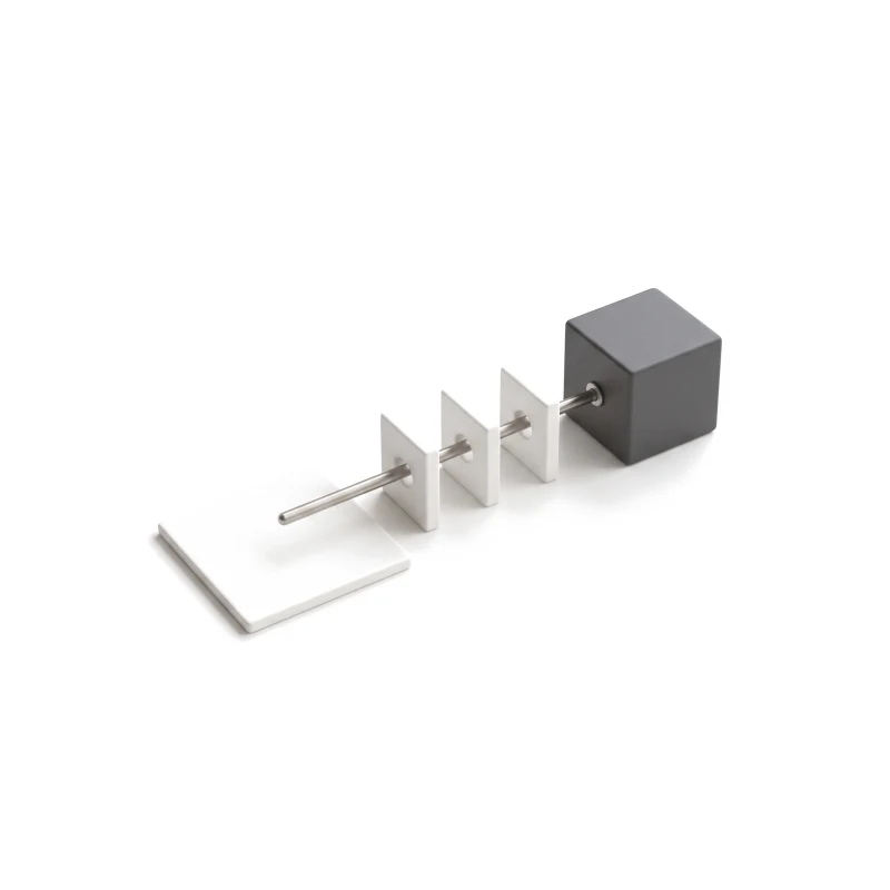 A flat ceramic sheet beside a steel rod that runs through three ceramic gate tiles into a graphite box.