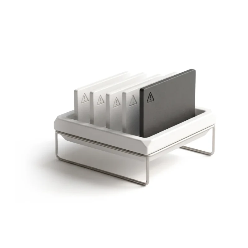A ceramic tray of alert cards with warning triangles, standing in order of height, the tallest in graphite.