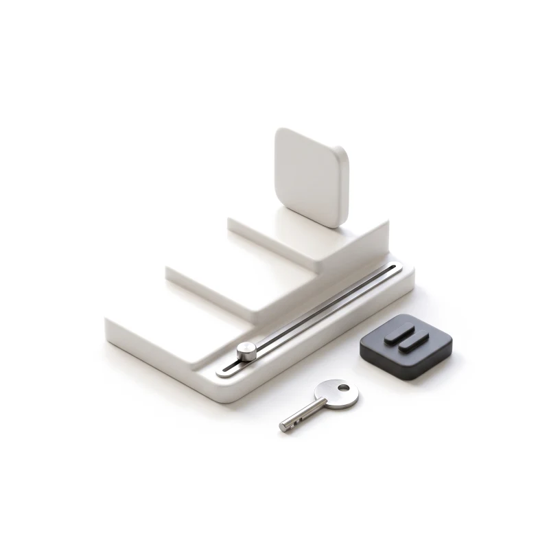 A stepped white ceramic plinth with an app-icon tile on the top step, a steel slider along its edge, a graphite pause block and a steel key beside it.