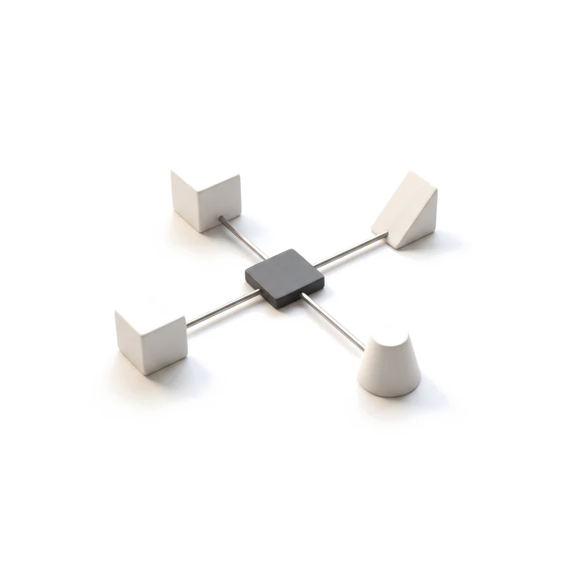 Four small ceramic blocks joined by thin steel rods to one graphite hub.