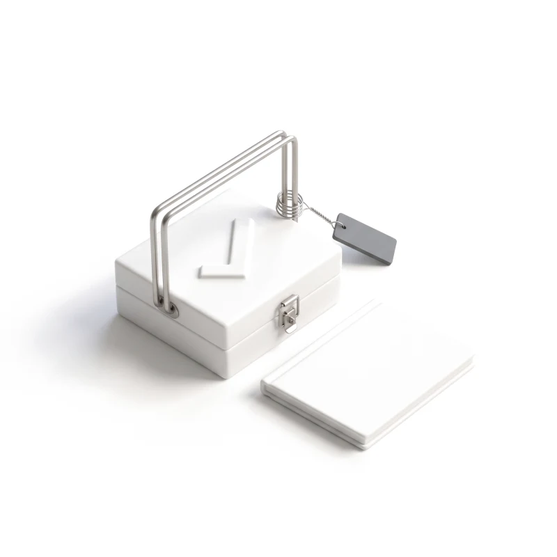 A closed white ceramic case with a steel handle and a raised check on its lid, a graphite tag hanging from it, a booklet beside.