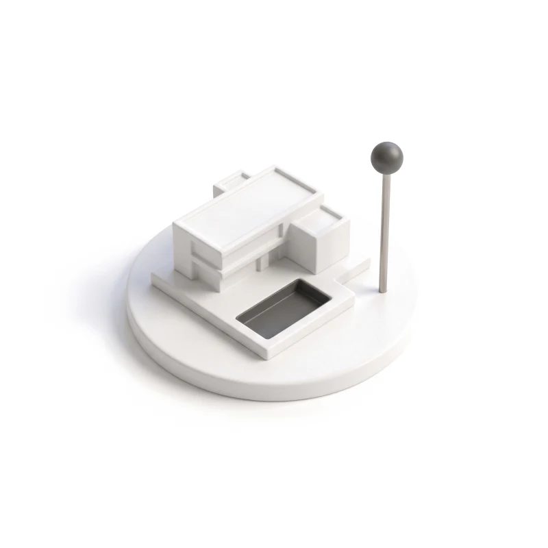 A small white ceramic villa with a carved pool on a round tile, a steel pin with a graphite head beside it.
