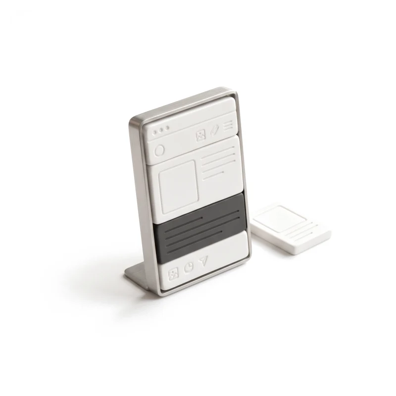 A ceramic browser window built from stacked blocks in a steel frame, one block graphite, a spare block lying beside it.