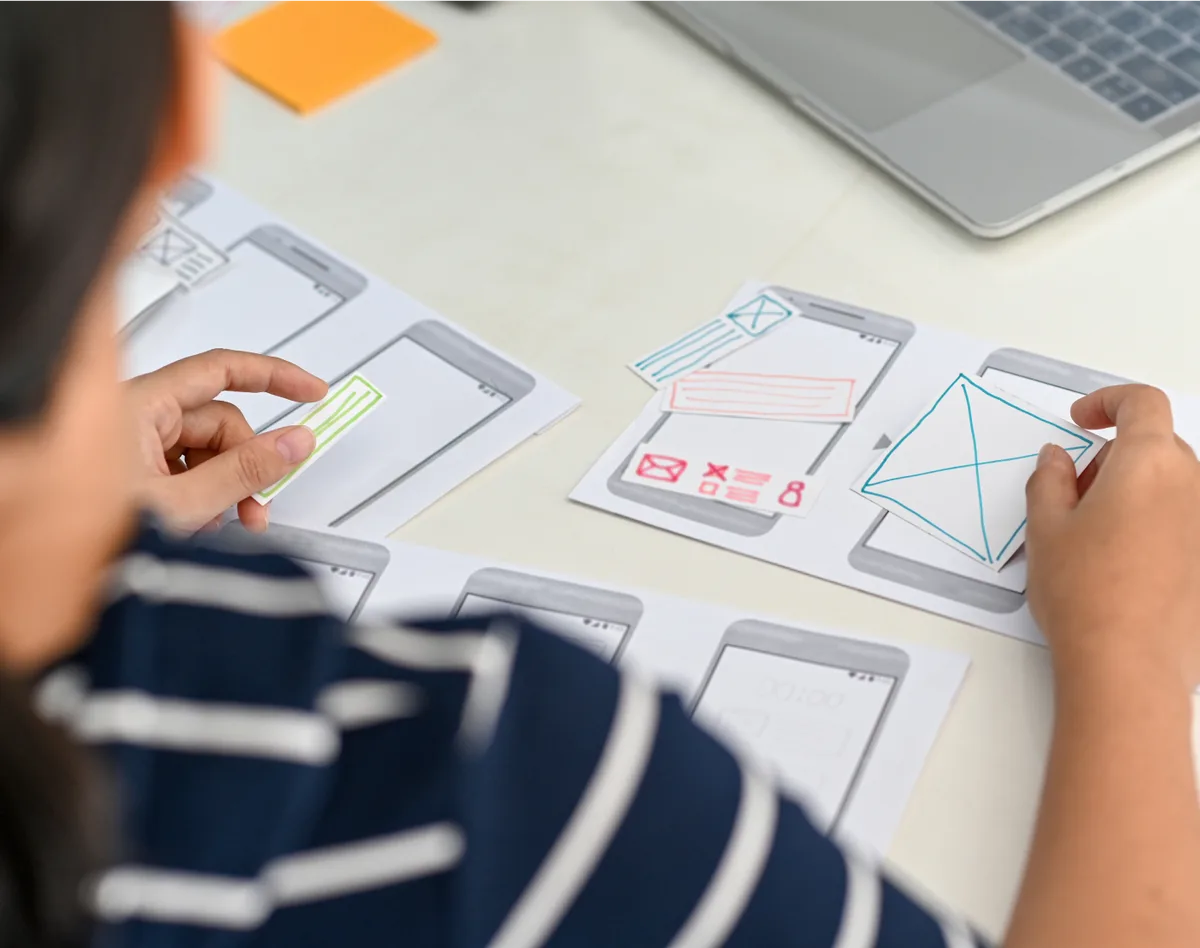 A person focused on developing a mobile app, illustrating best practices in UI design for effective user interfaces.