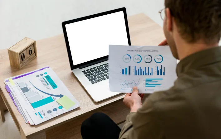 A man analyzing graphs on a laptop, focusing on effective dashboard design for visual appeal and functionality.